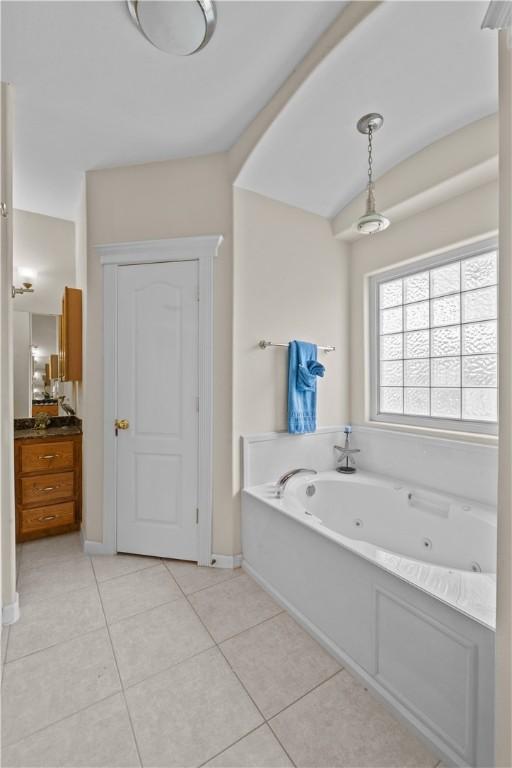 bathroom with toilet, vanity, and tile patterned flooring