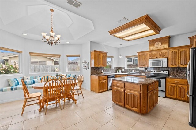 living room featuring light tile patterned flooring, ceiling fan, and a tray ceiling