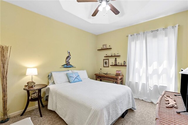 living room with light hardwood / wood-style flooring, ceiling fan, and a tray ceiling