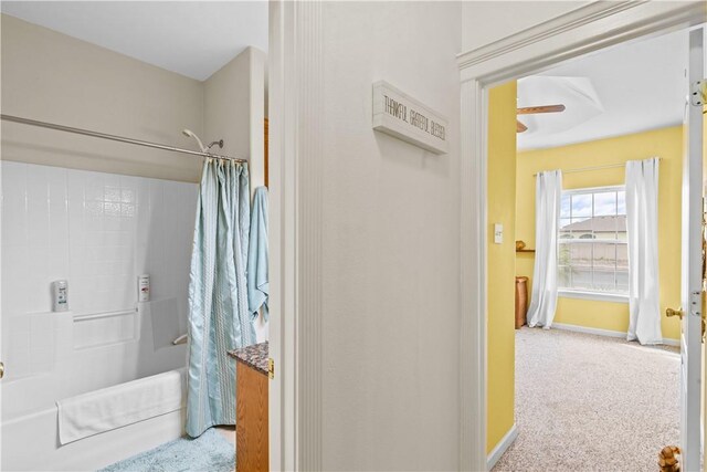 bedroom with a tray ceiling, carpet, and ceiling fan