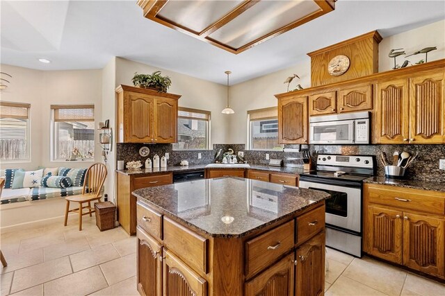 kitchen with a wealth of natural light, an inviting chandelier, a kitchen island, and dishwasher