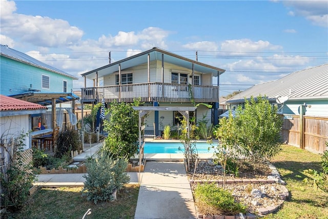 back of property with a fenced in pool