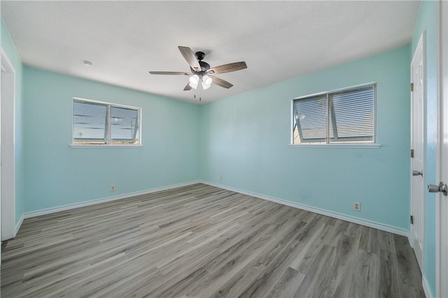 empty room with ceiling fan and light hardwood / wood-style flooring