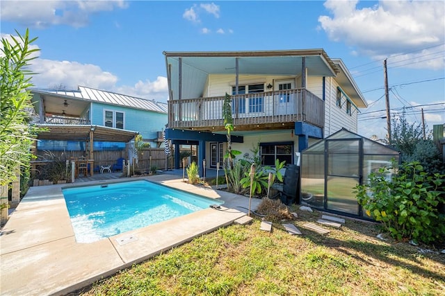 back of house featuring a fenced in pool and an outdoor structure