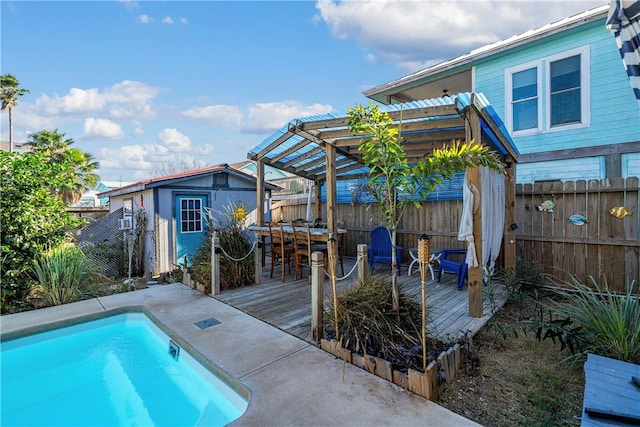 view of pool featuring a pergola, a wooden deck, a bar, and an outdoor structure