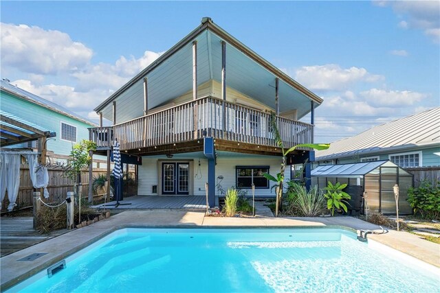 back of property with a pool side deck and a storage unit