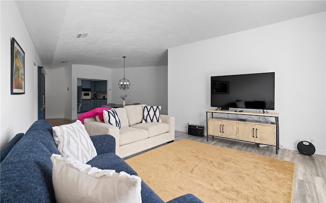 living room with a chandelier and wood-type flooring