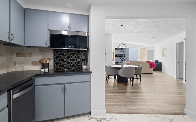 kitchen featuring pendant lighting, appliances with stainless steel finishes, tasteful backsplash, light hardwood / wood-style floors, and a chandelier