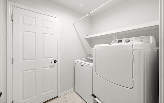 washroom with light tile patterned floors and washing machine and clothes dryer