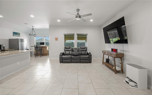 tiled living room featuring ceiling fan with notable chandelier