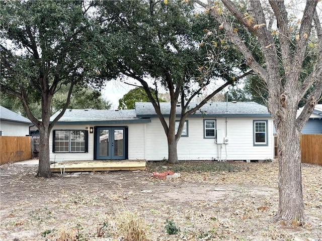 view of front facade featuring french doors, fence, and a wooden deck