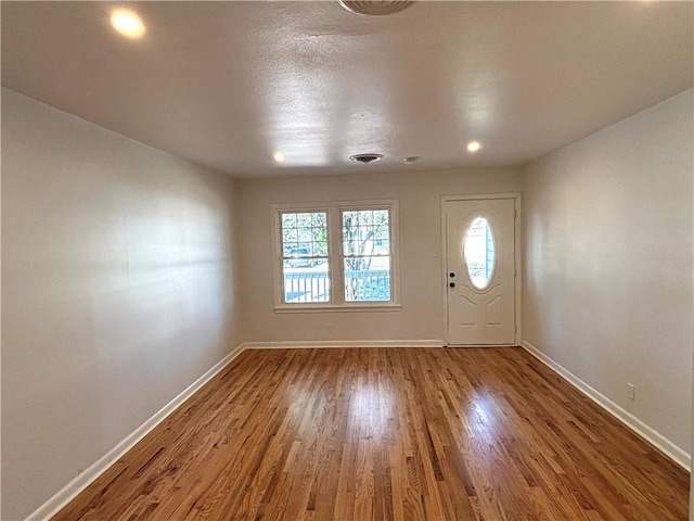 entrance foyer with visible vents, baseboards, and wood finished floors