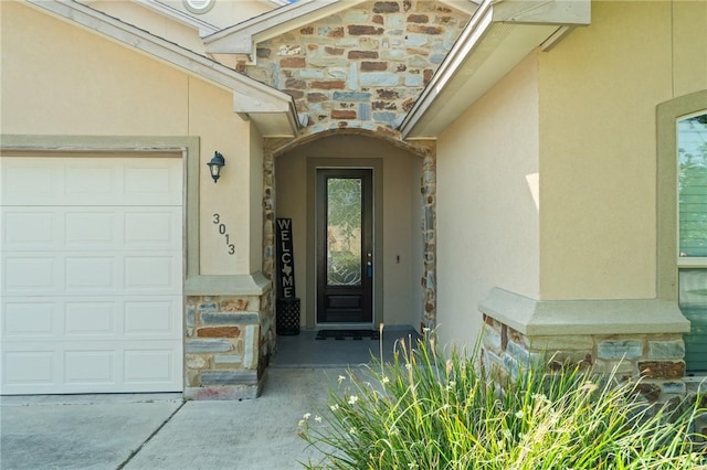 3013 Neches Dr, Corpus Christi, TX 78414 - doorway to property with stone siding, stucco siding, an attached garage, and concrete driveway
