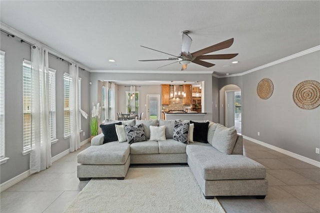 3013 Neches Dr, Corpus Christi, TX 78414 - living room featuring light tile patterned flooring, ornamental molding, arched walkways, a ceiling fan, and baseboards