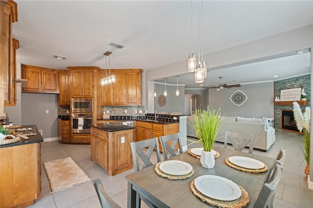 3013 Neches Dr, Corpus Christi, TX 78414 - kitchen with appliances with stainless steel finishes, dark countertops, a ceiling fan, and brown cabinets