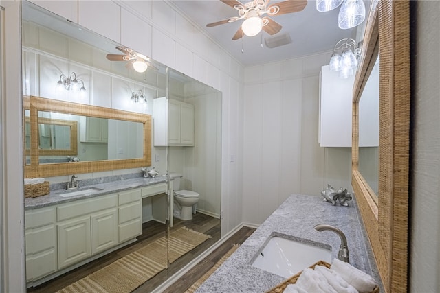 bathroom with wood-type flooring, vanity, toilet, and crown molding