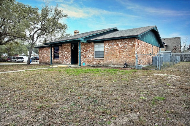 ranch-style home featuring central AC unit and a front lawn