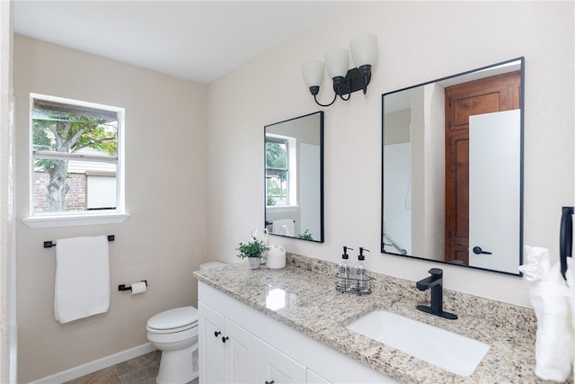 bathroom featuring vanity, tile patterned floors, and toilet