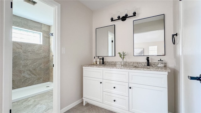 bathroom with vanity and a tile shower