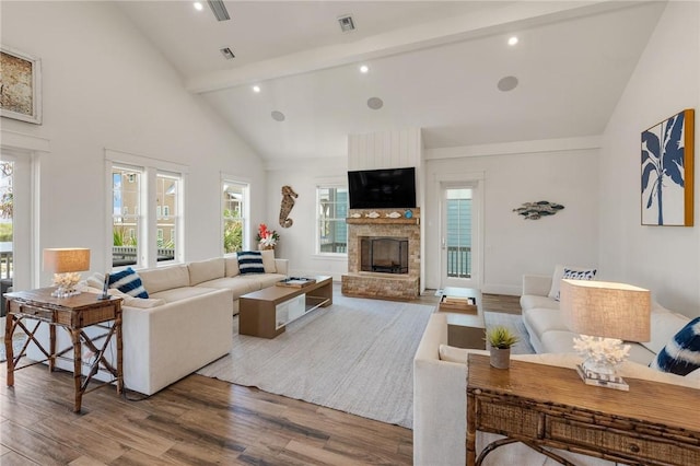 living room featuring beamed ceiling, high vaulted ceiling, a fireplace, and hardwood / wood-style flooring