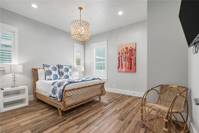 bedroom with hardwood / wood-style floors and a notable chandelier