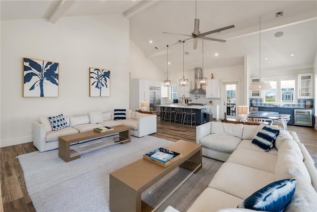 living room featuring beamed ceiling, ceiling fan, dark wood-type flooring, and beverage cooler