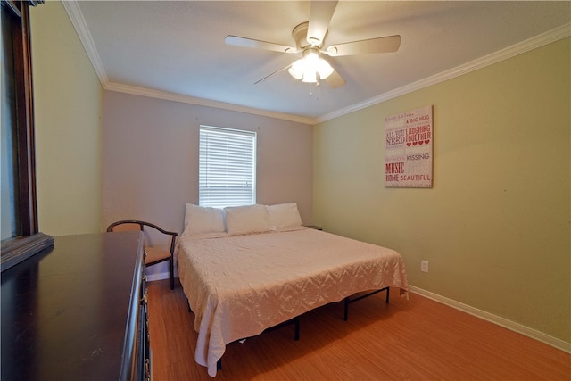 bedroom with hardwood / wood-style floors, ceiling fan, and crown molding