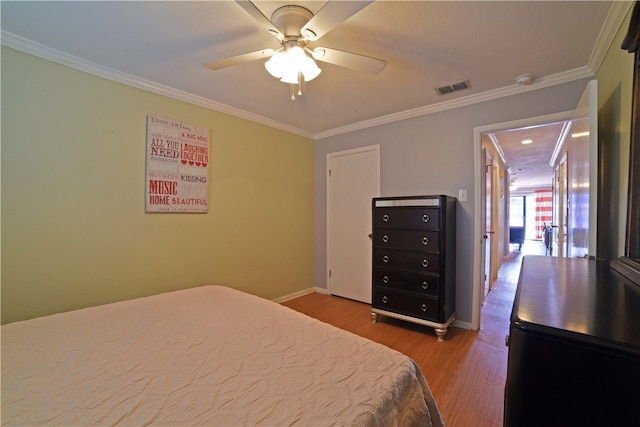 bedroom with ornamental molding, light wood-type flooring, and ceiling fan