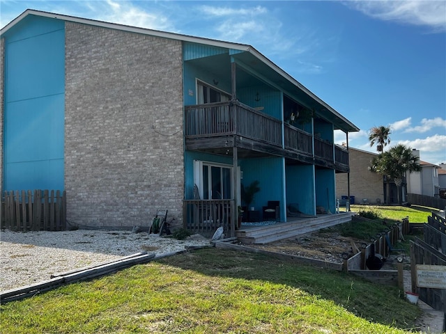 rear view of property with a yard and a balcony