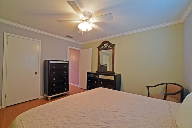 bedroom featuring hardwood / wood-style flooring, ceiling fan, and ornamental molding