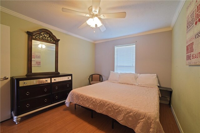 bedroom featuring ornamental molding, hardwood / wood-style floors, and ceiling fan