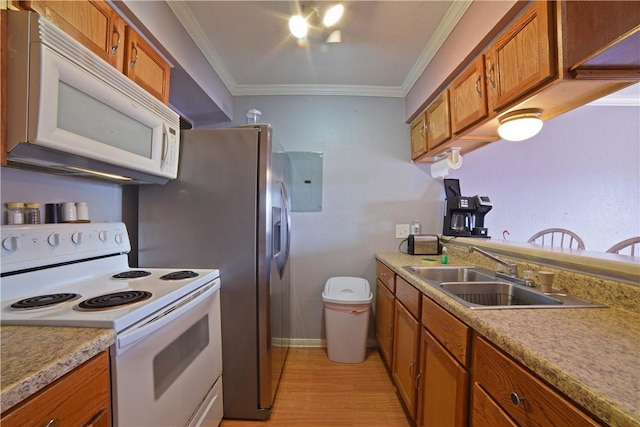 15426 Fortuna Bay Dr Unit 103, Corpus Christi, TX 78418 - kitchen with white appliances, brown cabinetry, a sink, ornamental molding, and light wood finished floors