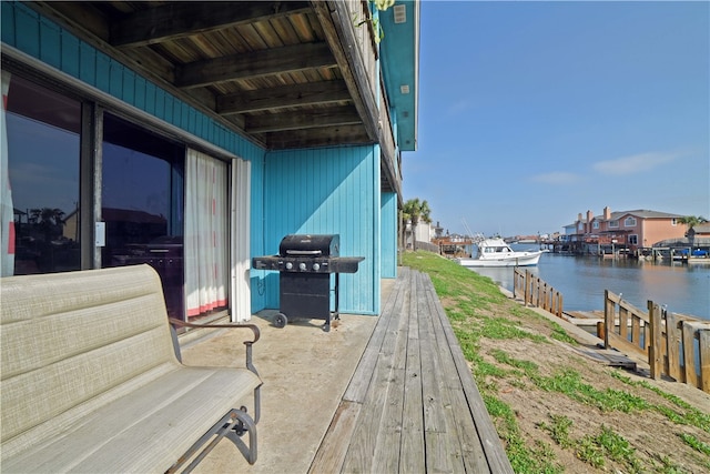 deck with grilling area and a water view