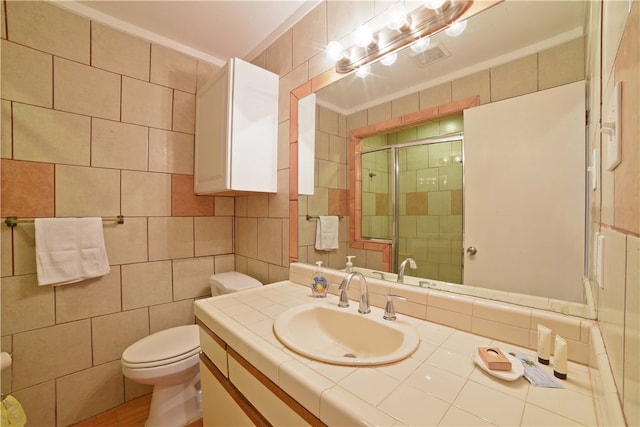 bathroom featuring tile walls, walk in shower, toilet, and vanity