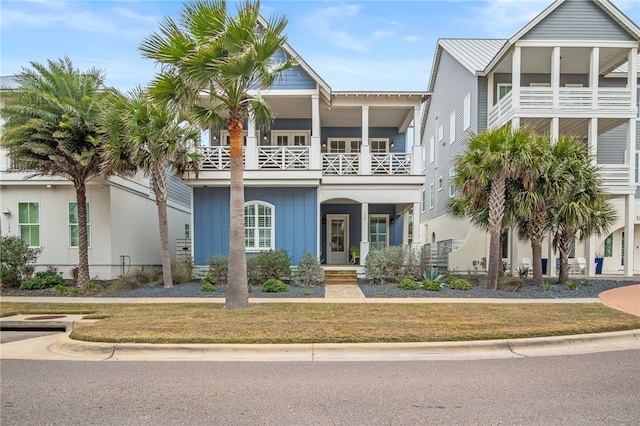 view of front of property featuring a balcony and a front yard