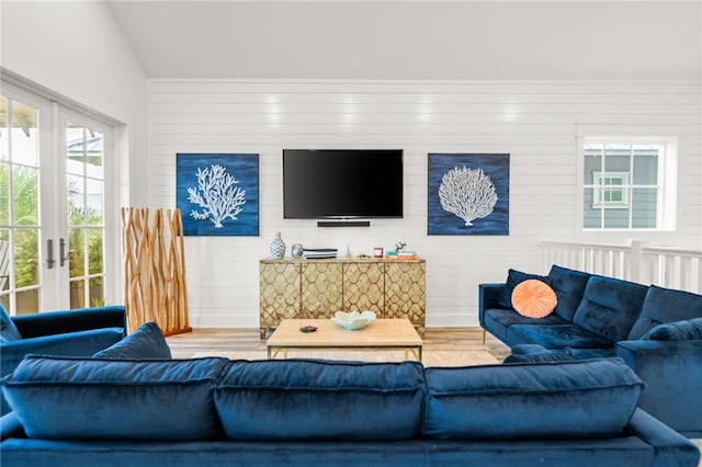 living area featuring lofted ceiling and french doors