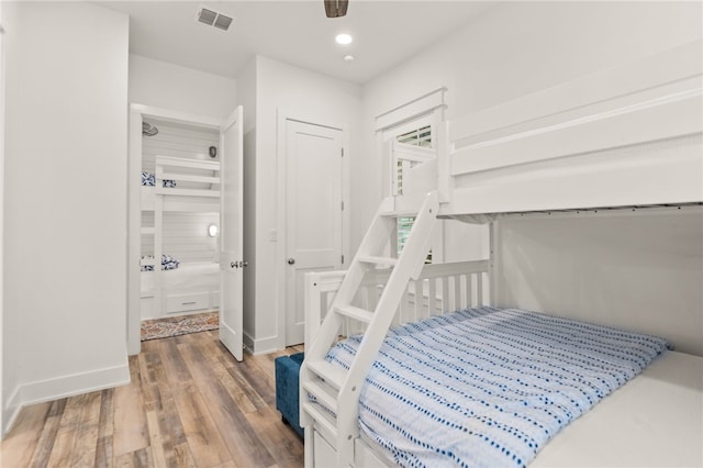 bedroom featuring baseboards, wood finished floors, visible vents, and recessed lighting