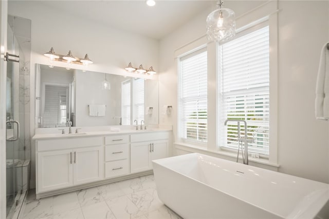 bathroom with a stall shower, a freestanding bath, marble finish floor, and a sink