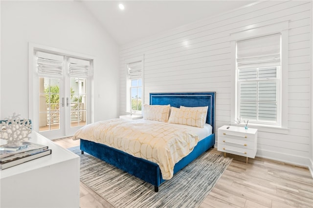 bedroom featuring access to exterior, baseboards, light wood finished floors, and french doors