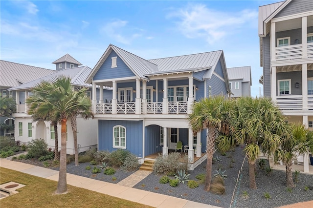 view of front facade with a standing seam roof, metal roof, and a balcony