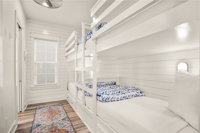 bedroom featuring wood walls and wood finished floors