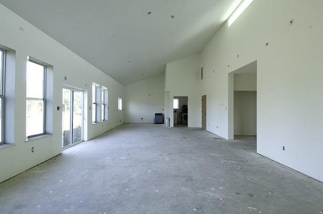 unfurnished living room featuring high vaulted ceiling