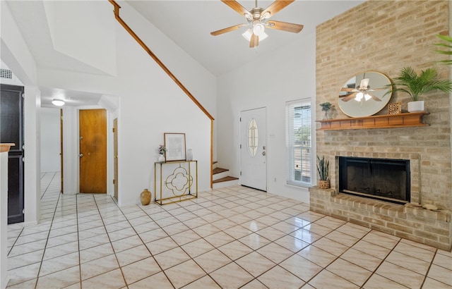 102 Mallard Dr, Aransas Pass, TX 78336 - unfurnished living room featuring ceiling fan, high vaulted ceiling, stairway, a fireplace, and light tile patterned floors
