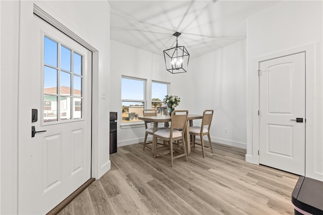 dining room with light wood-type flooring and an inviting chandelier