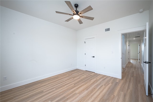 unfurnished bedroom with light wood-type flooring, ceiling fan, and a closet