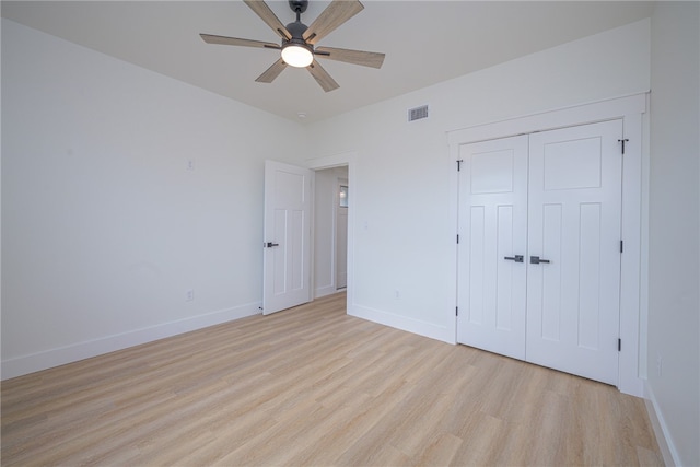 unfurnished bedroom featuring light hardwood / wood-style floors, ceiling fan, and a closet