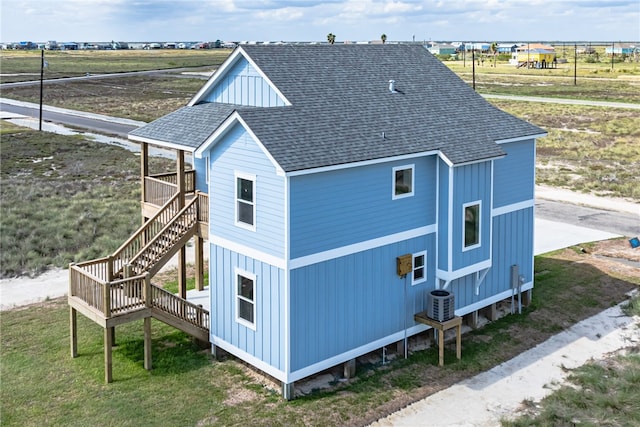 view of side of property featuring a lawn and cooling unit