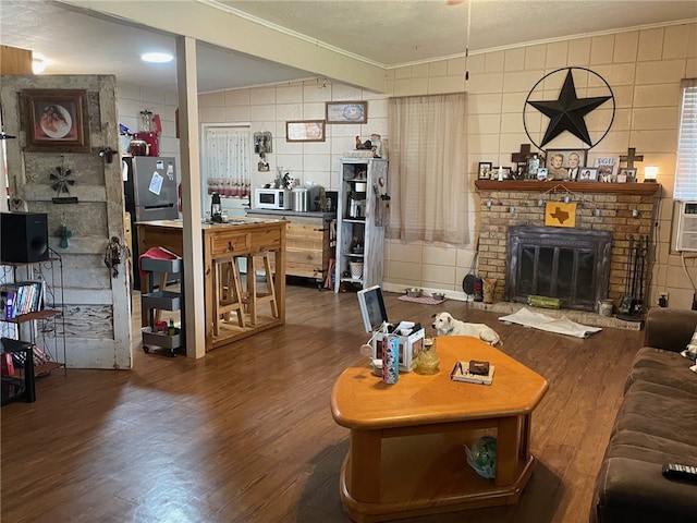 living room with hardwood / wood-style floors, a fireplace, and crown molding