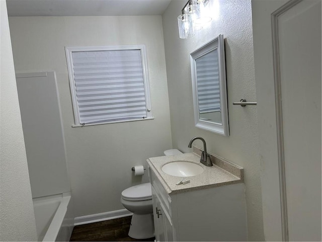 4822 Dodd Dr, Corpus Christi, TX 78415 - bathroom with vanity, toilet, a tub to relax in, wood finished floors, and baseboards