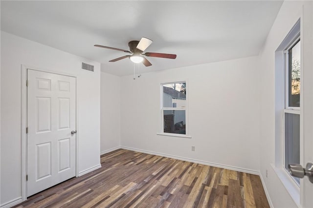 unfurnished room featuring dark wood-type flooring and ceiling fan